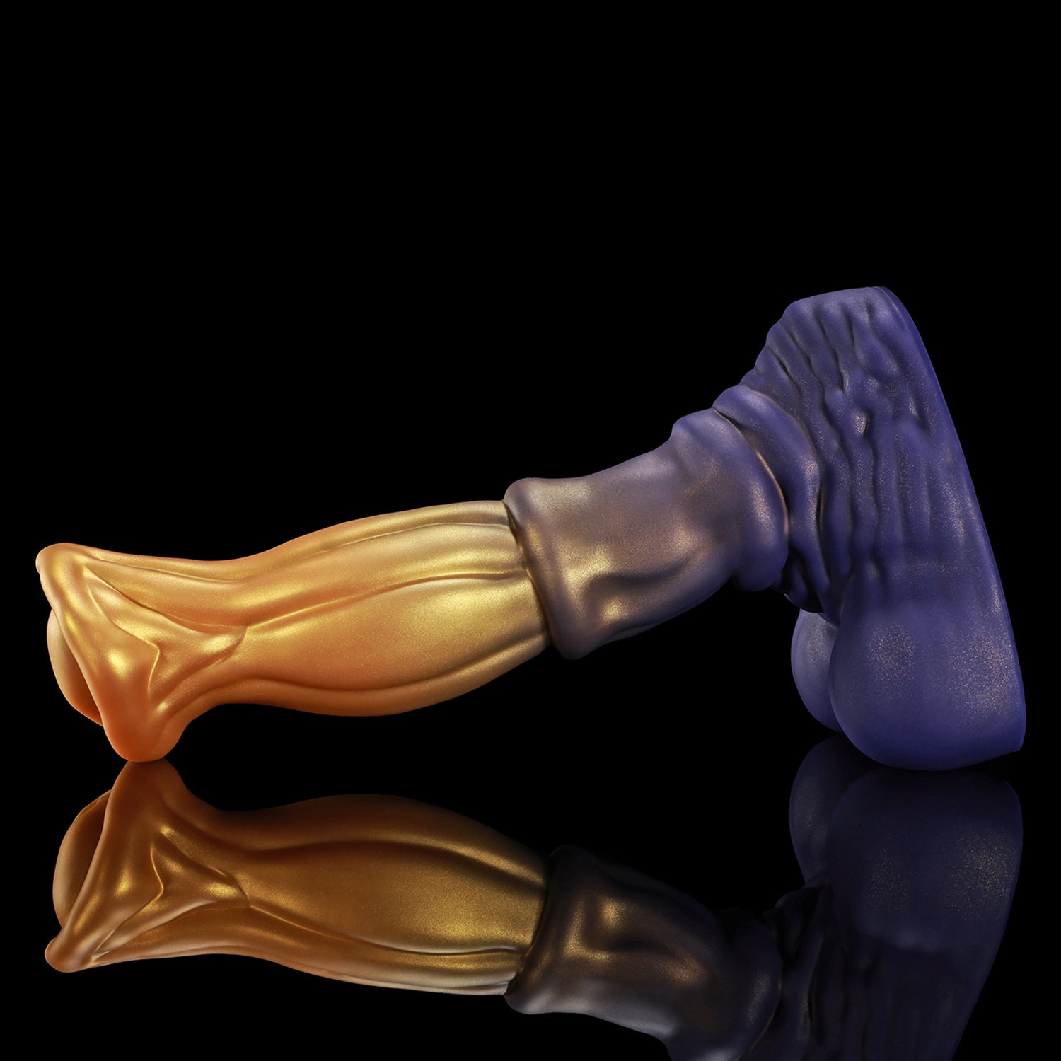 ANUBIS fantasy dildo with a sculpted tapered shaft, flared head, and rounded base - gold and purple angled view