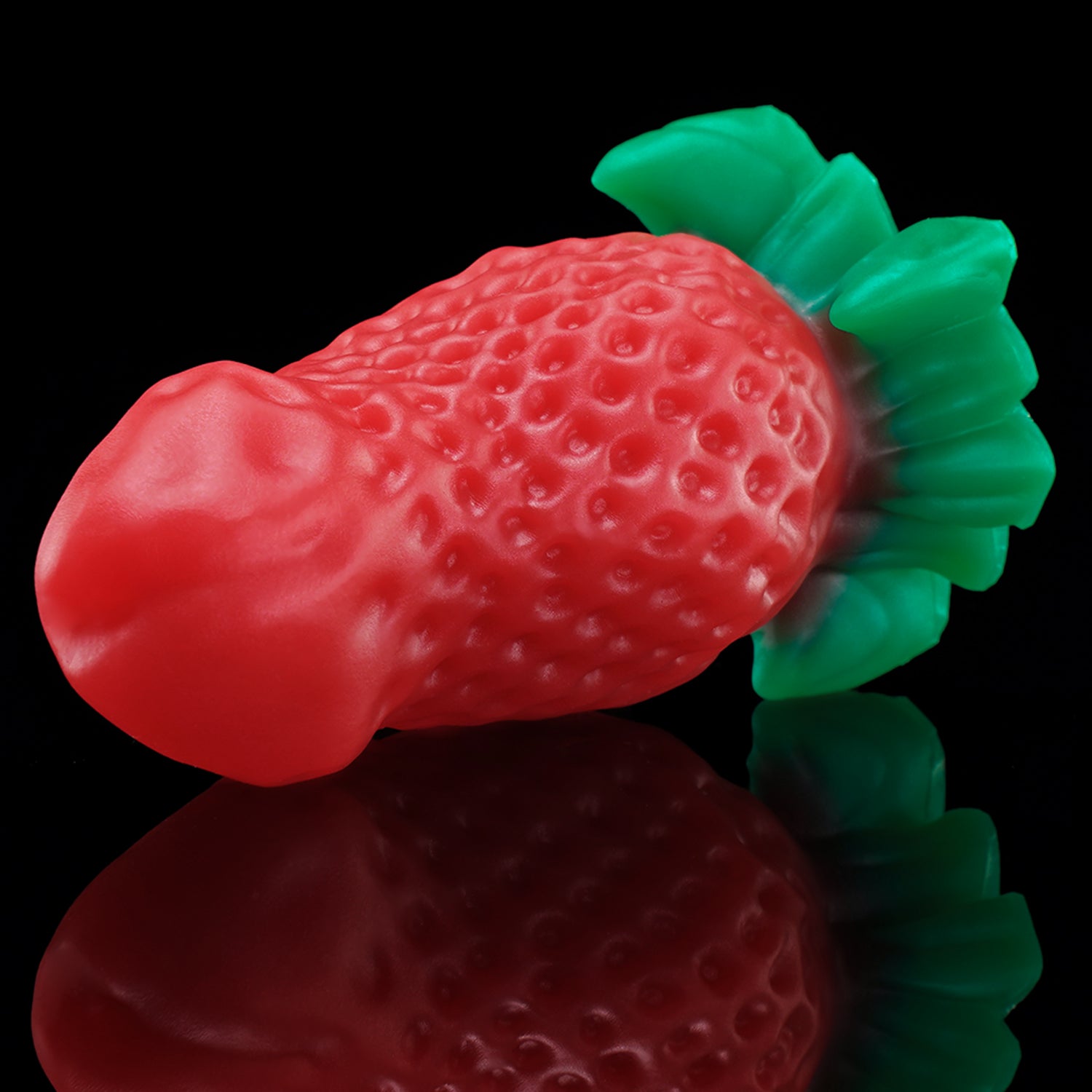 BERRYBLOOM fantasy strawberry butt plug with seed texture, leafy base, and rounded tip - red angled side view
