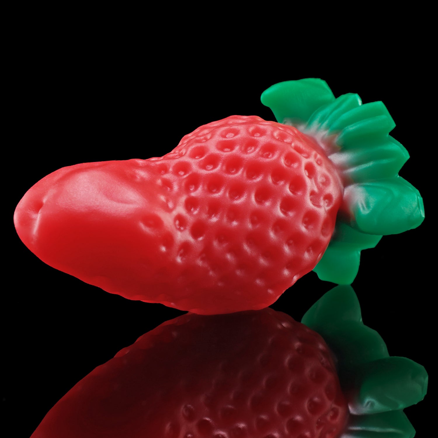 BERRYBLOOM fantasy strawberry butt plug with seed texture, leafy base, and rounded tip - red low side view