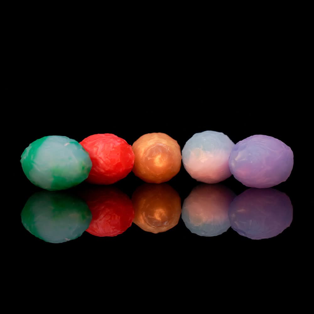 Translucent green oviposition egg with wrinkled veiny texture on black background.
